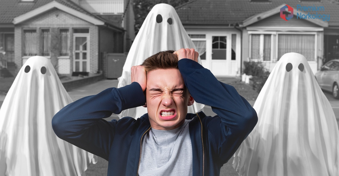 Мужчина сидит на земле и держится за голову