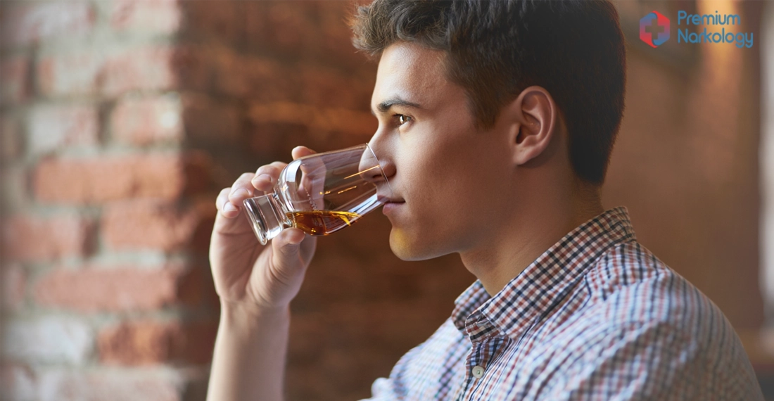 Мужчина пьёт алкоголь из бокала