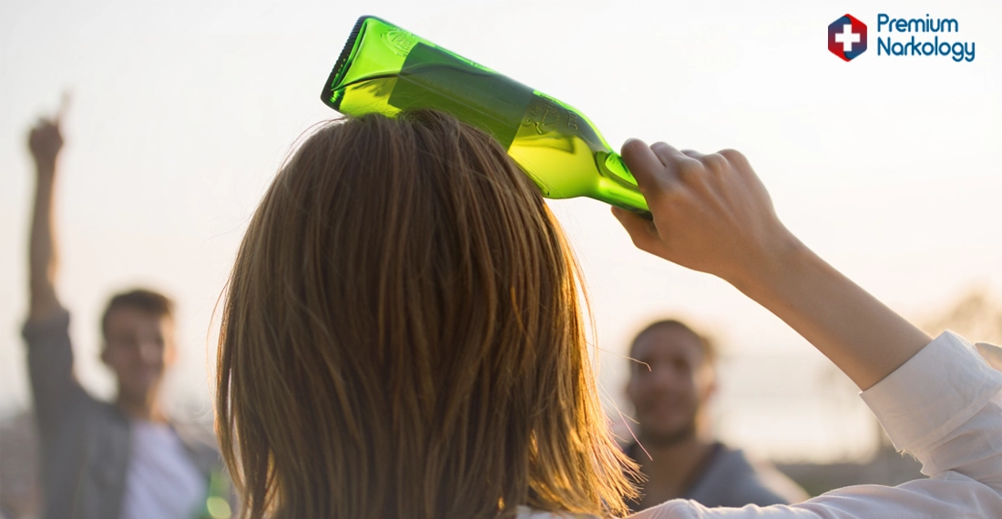 Девушка замахивается пустой бутылкой