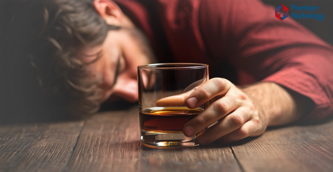 Мужчина со стаканом в руке спит за столом